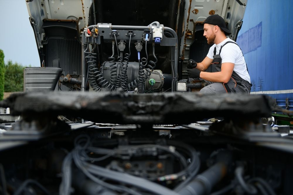 A Man Is Working On The Engine Of A Truck — Wards Byron Shire Truck & Machinery Centre In Tyagarah, NSW