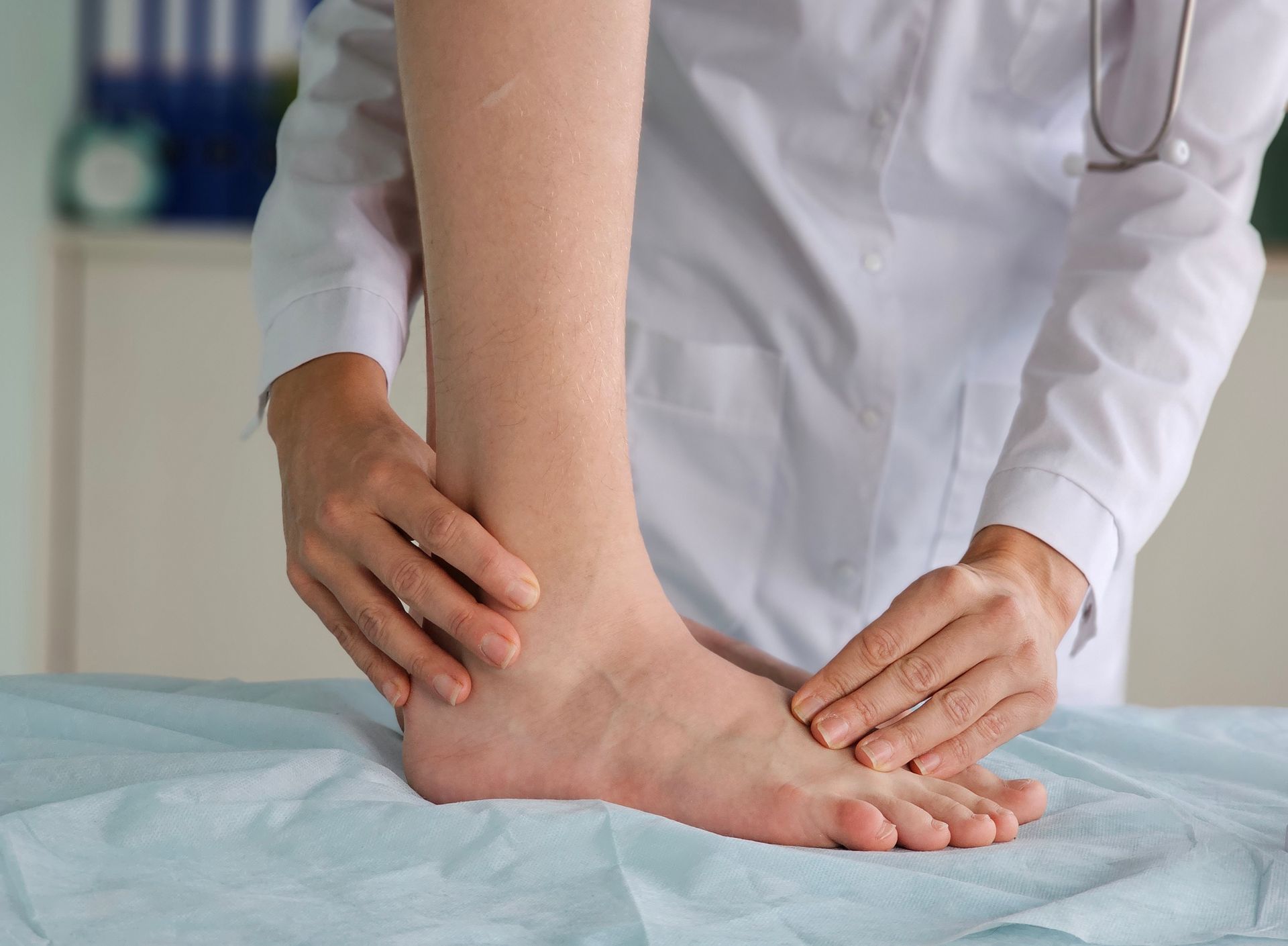 Doctor examining a patient's foot on an examination table.