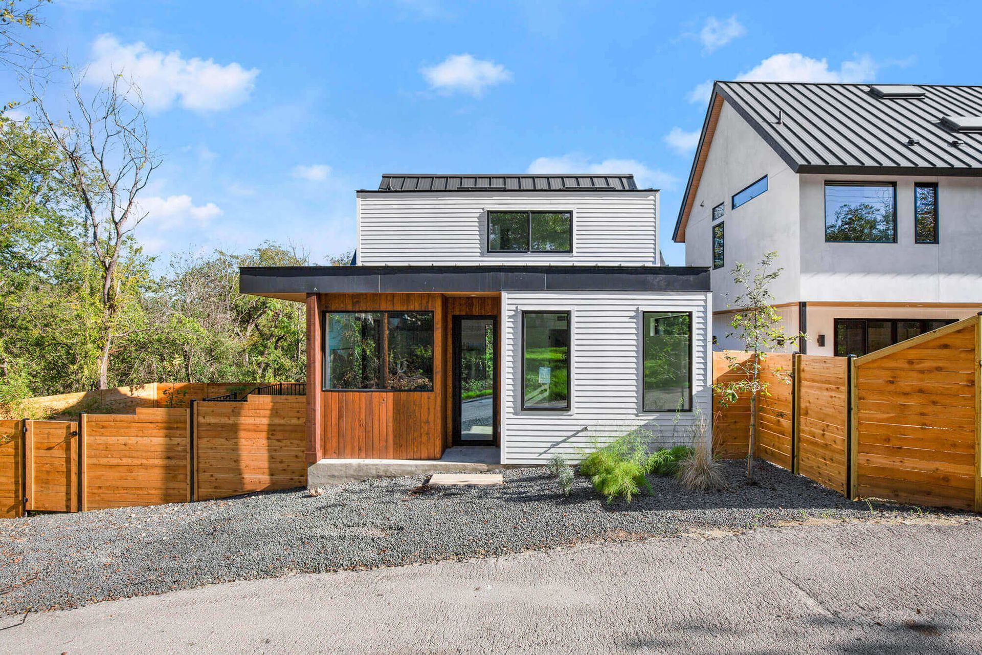 a small white house with a wooden fence in front of it .