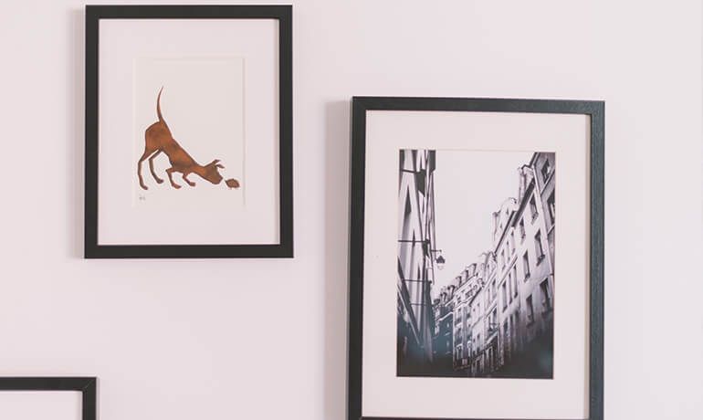 Framed wall art: a brown bull print and a black-and-white city street photograph.