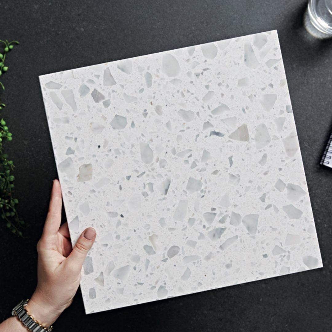 A Person Is Holding a Piece of White Tile — Peninsula Tiles in Umina Beach, NSW