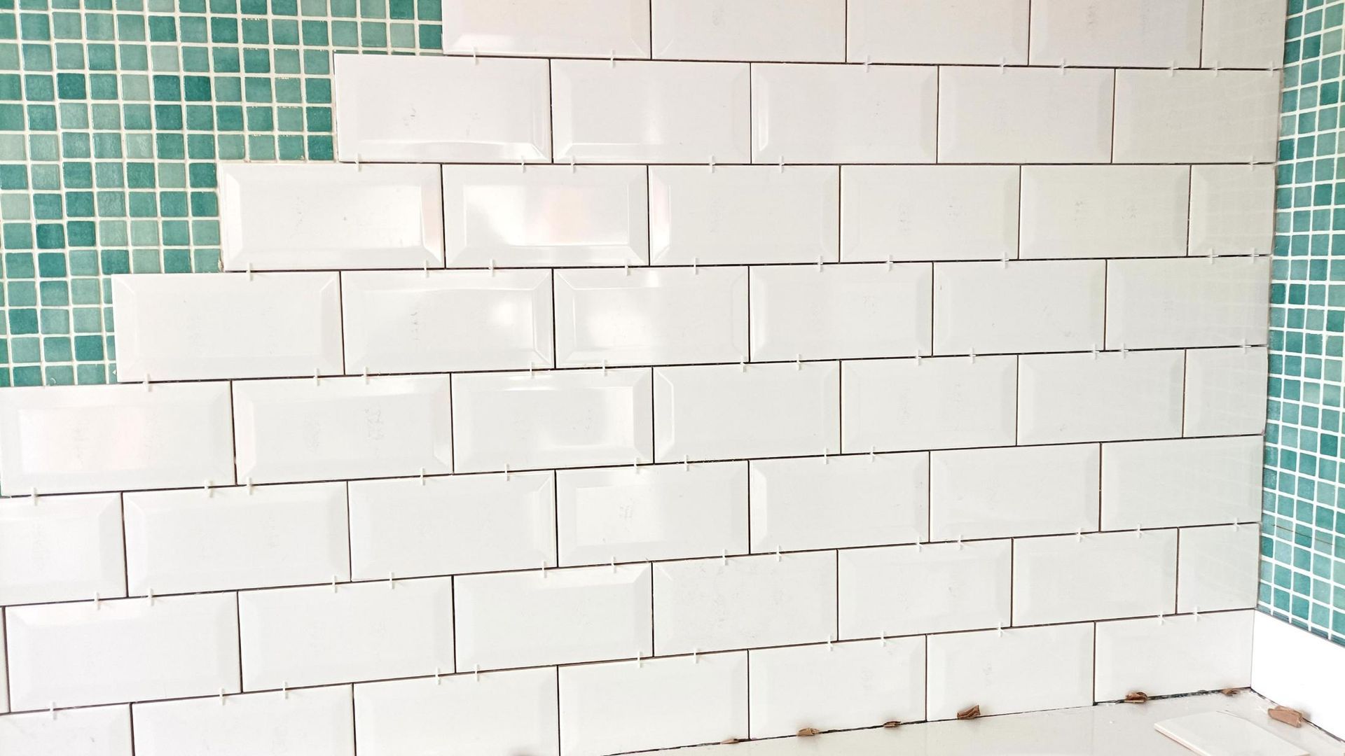 A Wall of White Tiles Is Being Installed in A Bathroom — Peninsula Tiles in Umina Beach, NSW