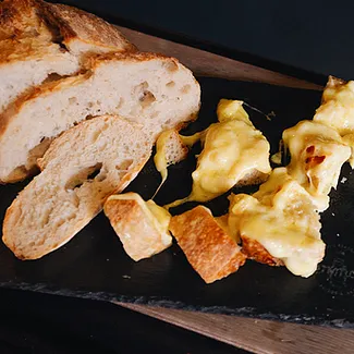Fatias de pão e queijo em um prato preto