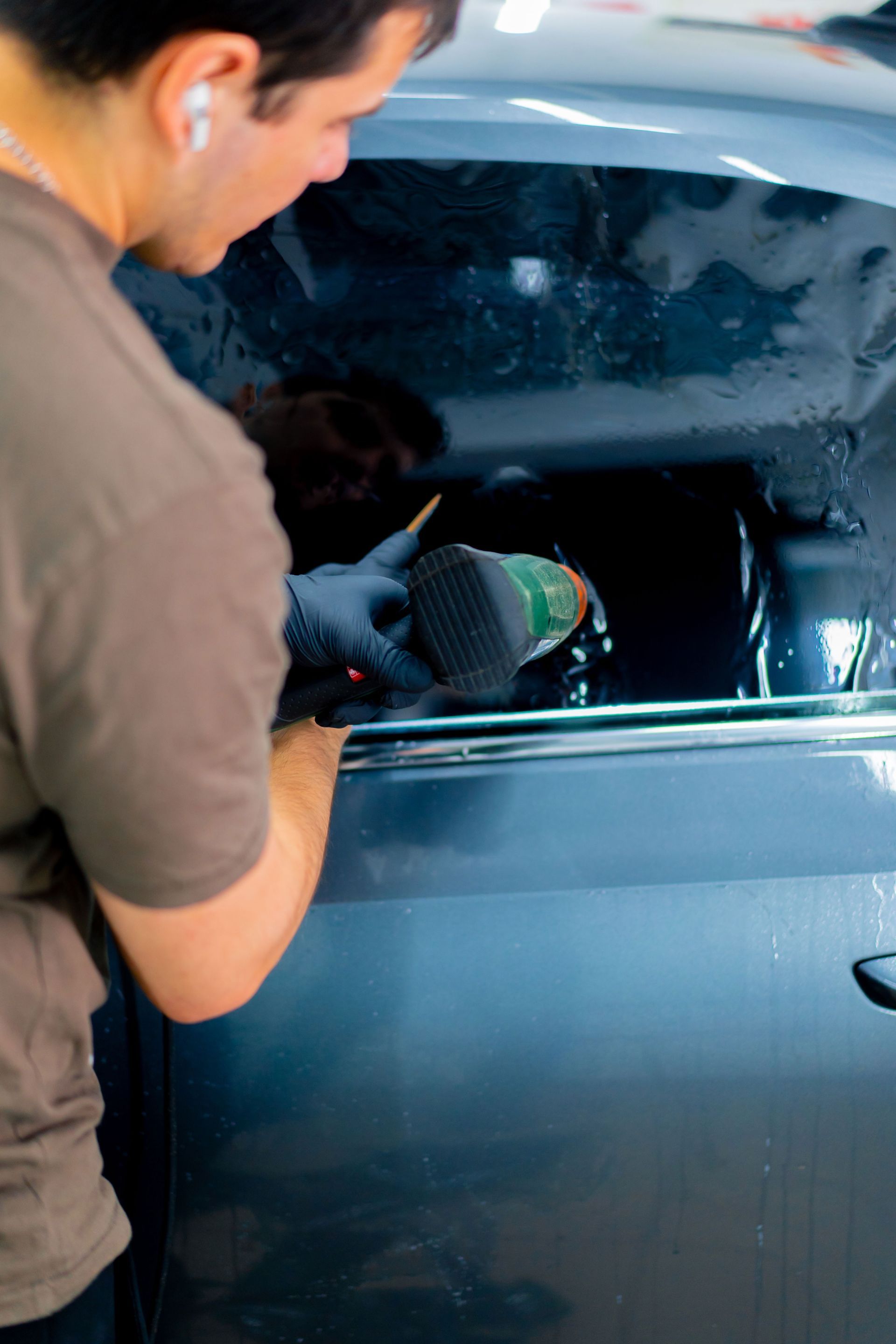 A man is installing window tint to a car