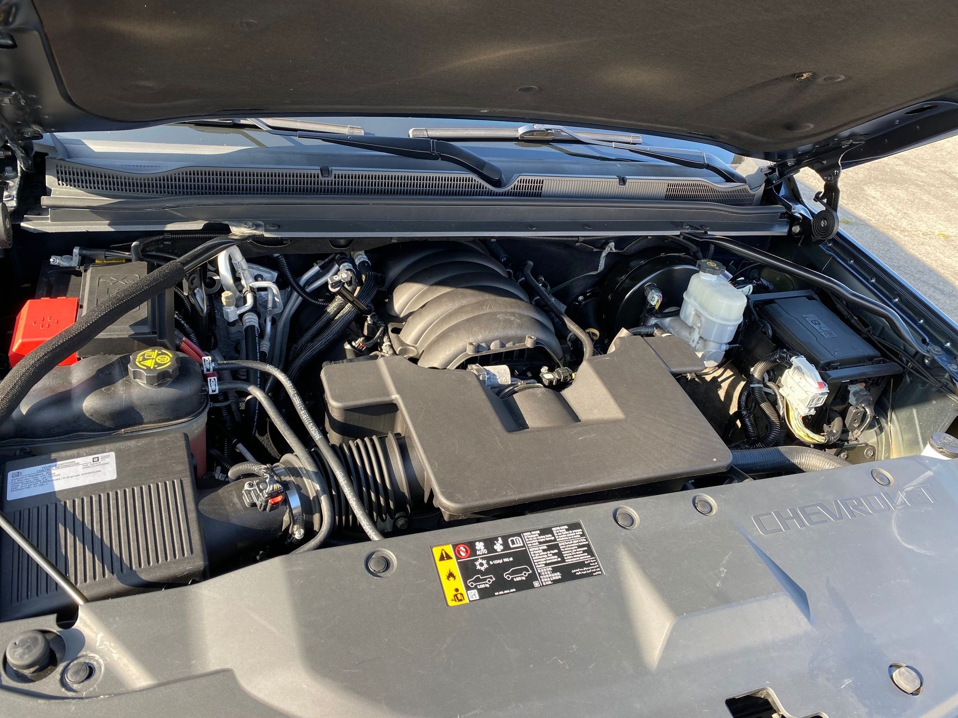 A close up of the engine of a car with the hood open.
