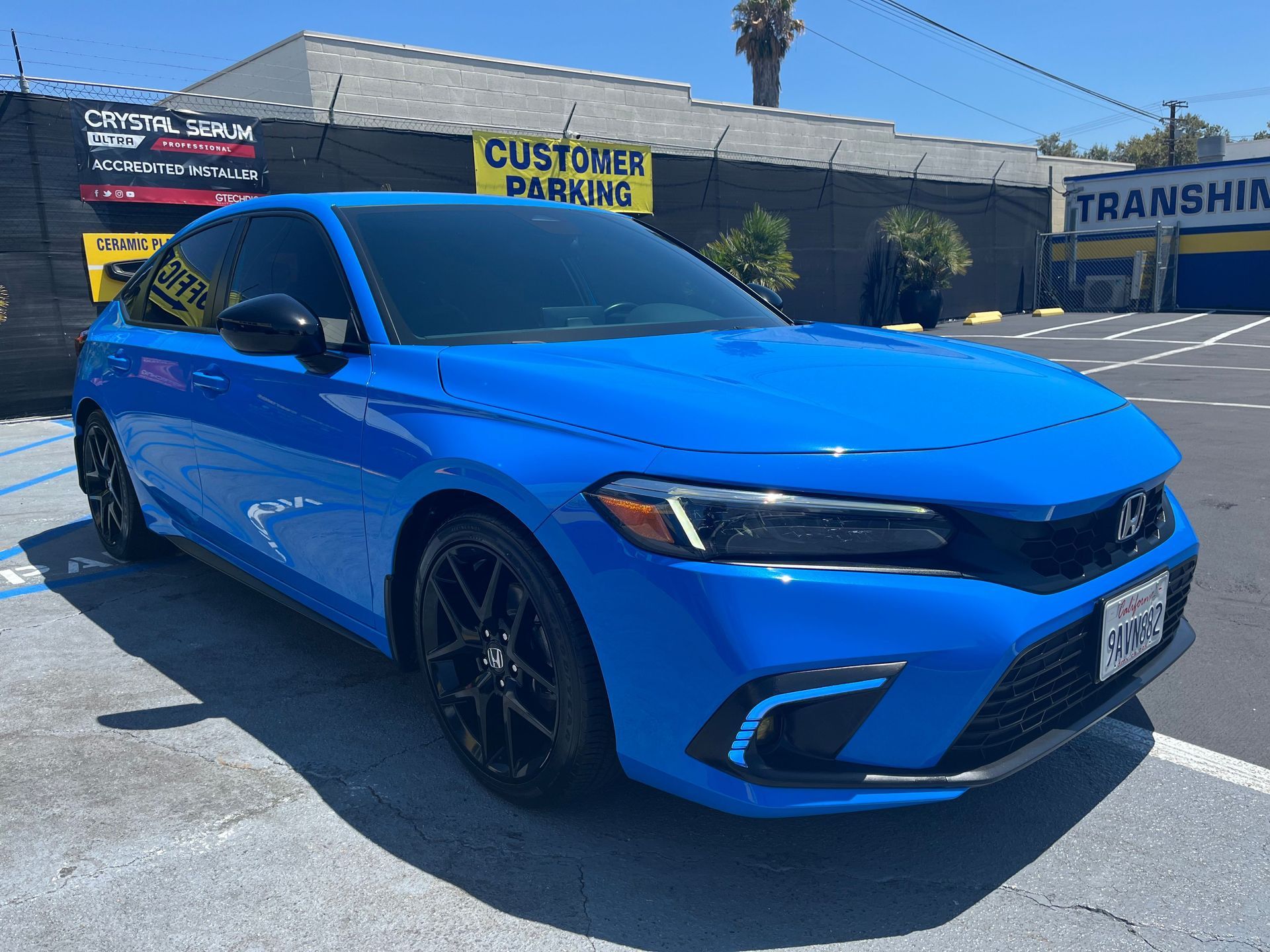 A blue honda civic is parked in a parking lot.