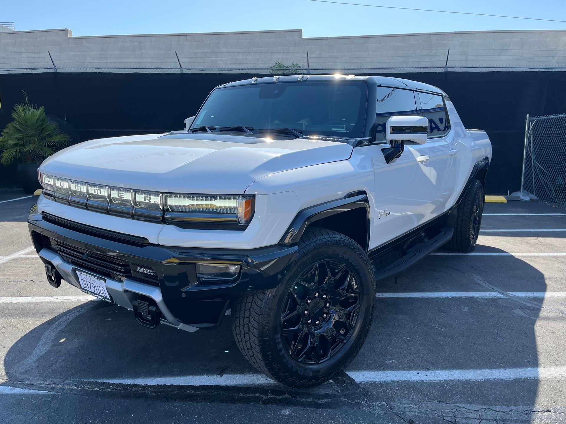 A white hummer truck is parked in a parking lot.