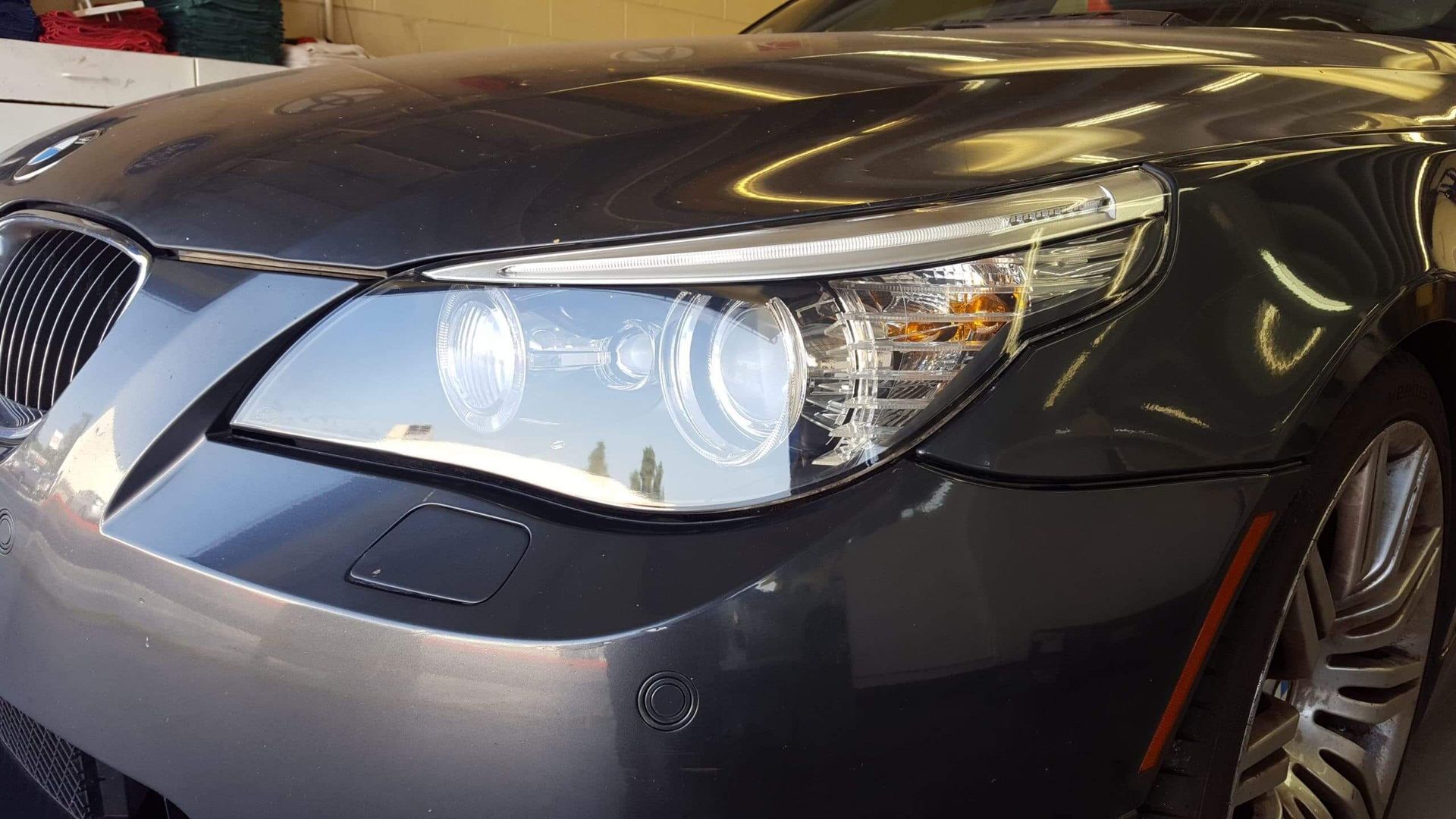 A close up of a car 's headlight in a garage.