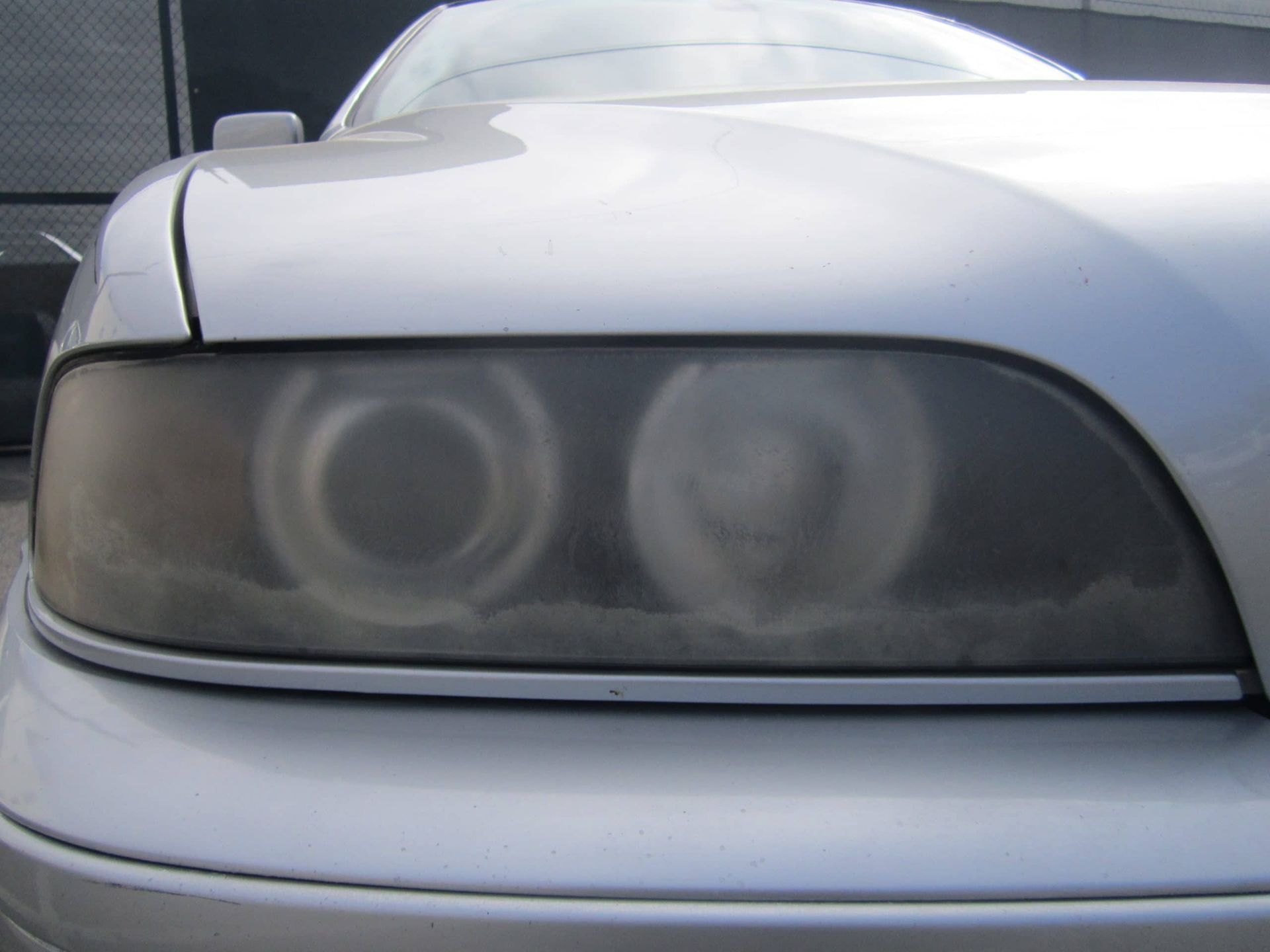 A close up of a car 's headlight that is dirty