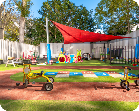 Outdoor play area with tricycles at Kinder Academy