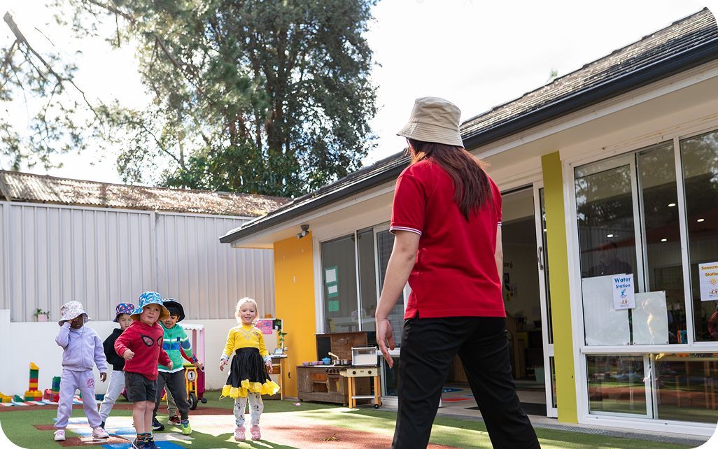 Children enjoying outdoor play with an educator at Kinder Academy