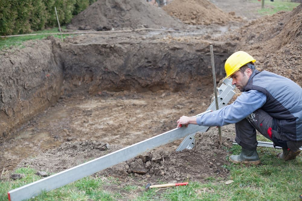 A Blue Swimming Pool is Being Install Beside a House Yard — Hoges Plumbing In West Wollongong, NSW