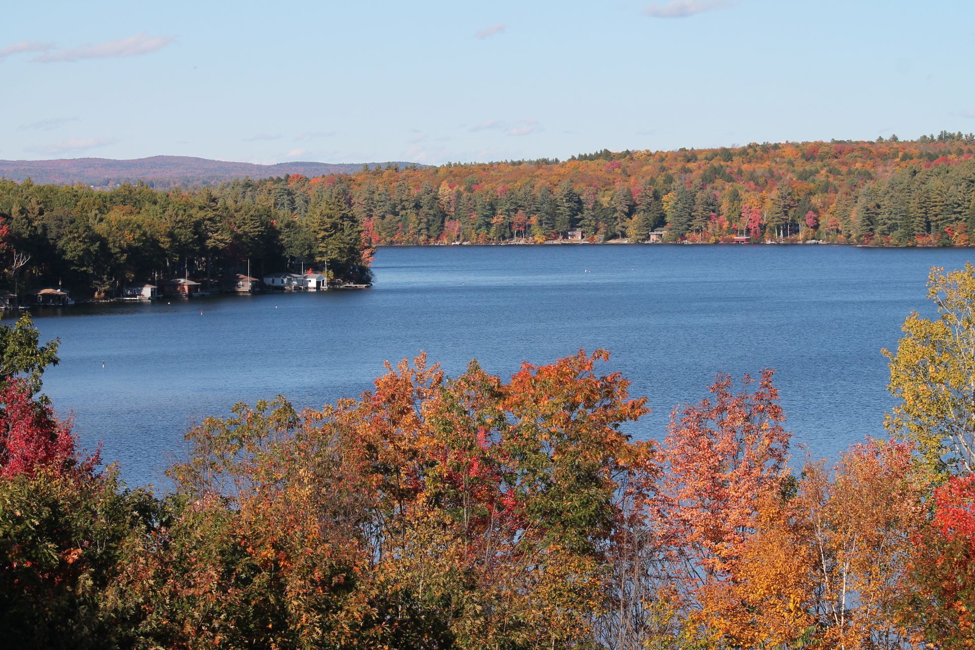 Autumn lake scene with colorful fall foliage and blue water.