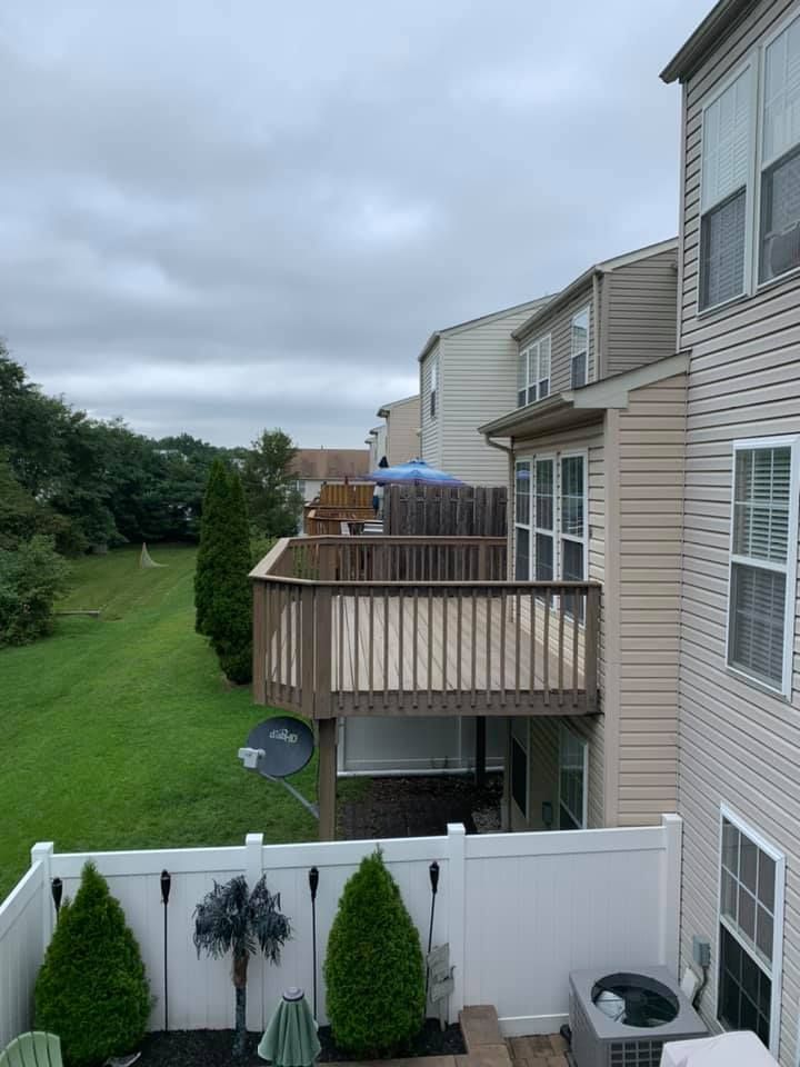 Apartment balconies beside a grassy courtyard under a cloudy sky