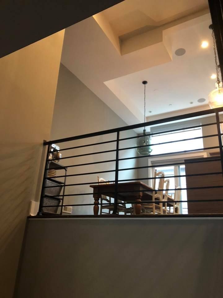 Interior loft dining area with railing, pendant light, and high ceiling