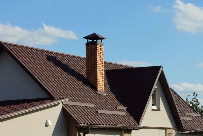 A brick chimney on the roof of a house.