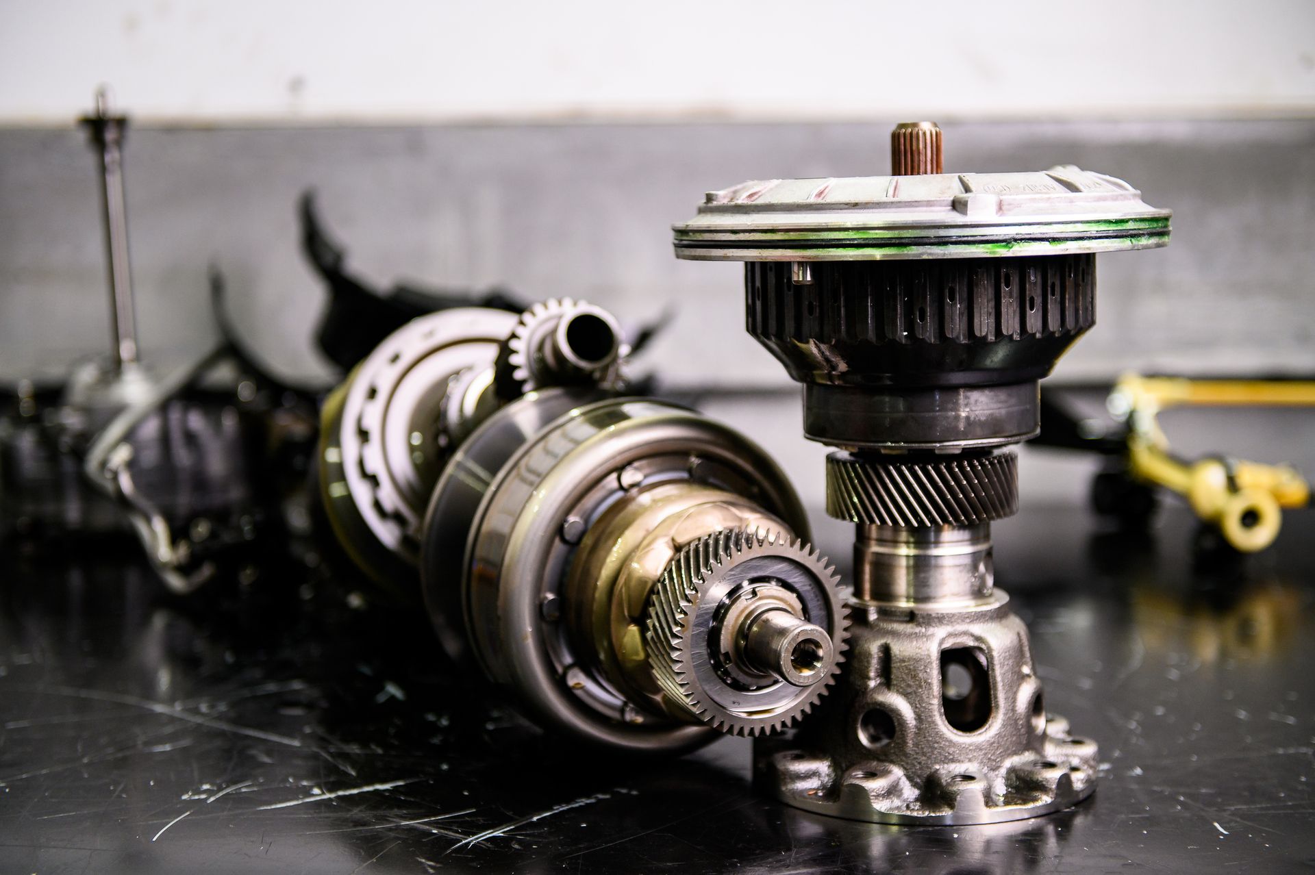 Close-up of disassembled gears and transmission on table from a used auto part yard inventory.