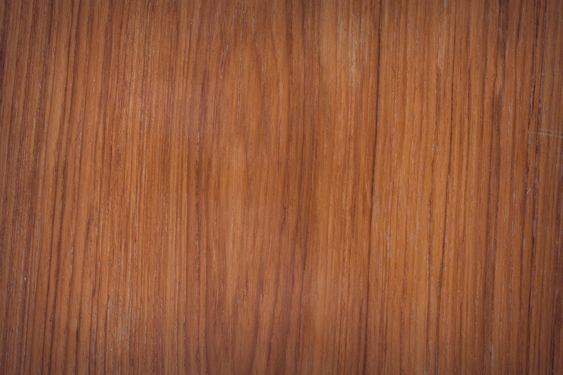 Gros plan du grain du bois brun avec des lignes verticales et différentes nuances de couleurs.