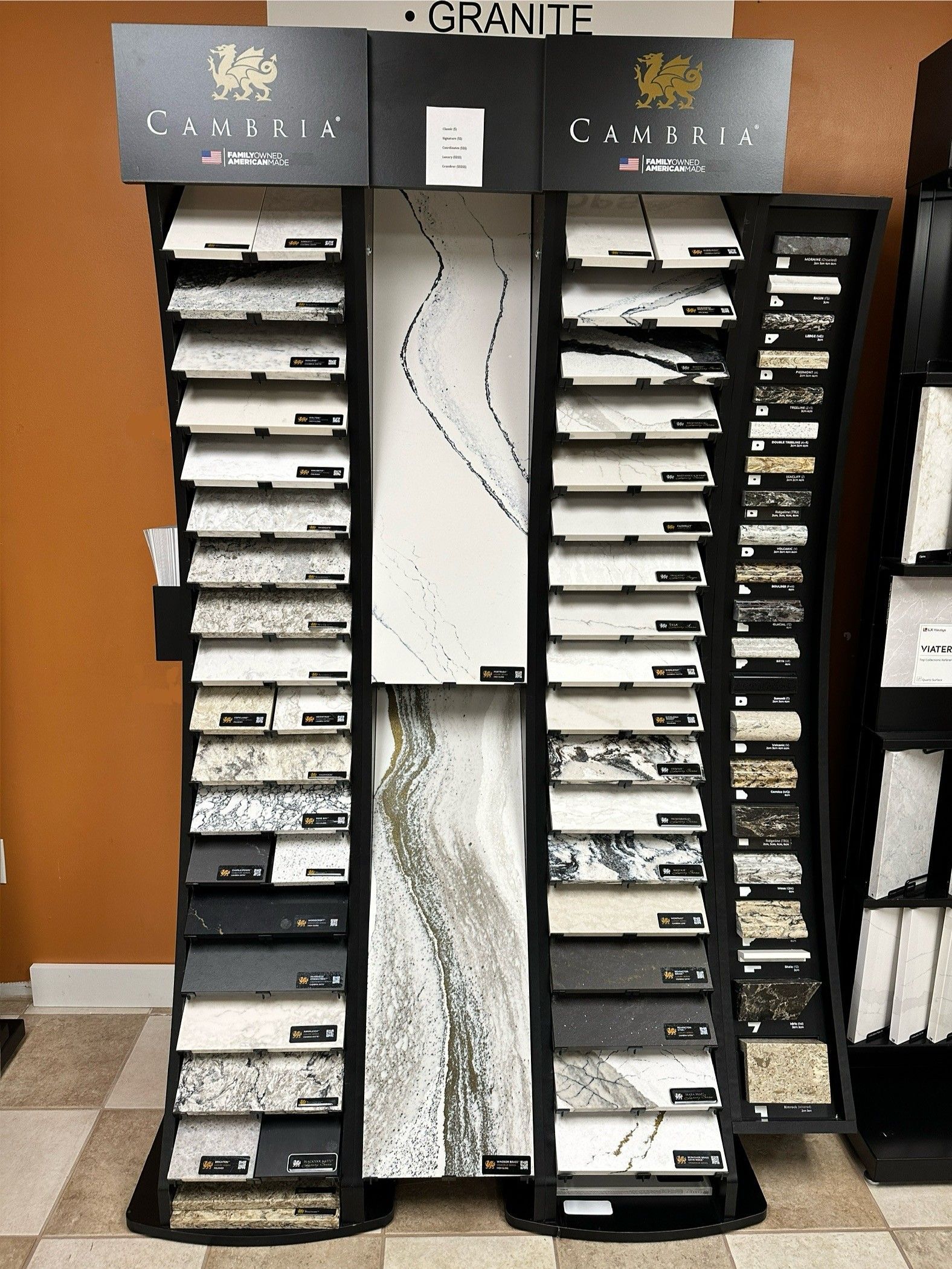 Display of granite countertop samples in a showroom, with varying colors and patterns arranged vertically.
