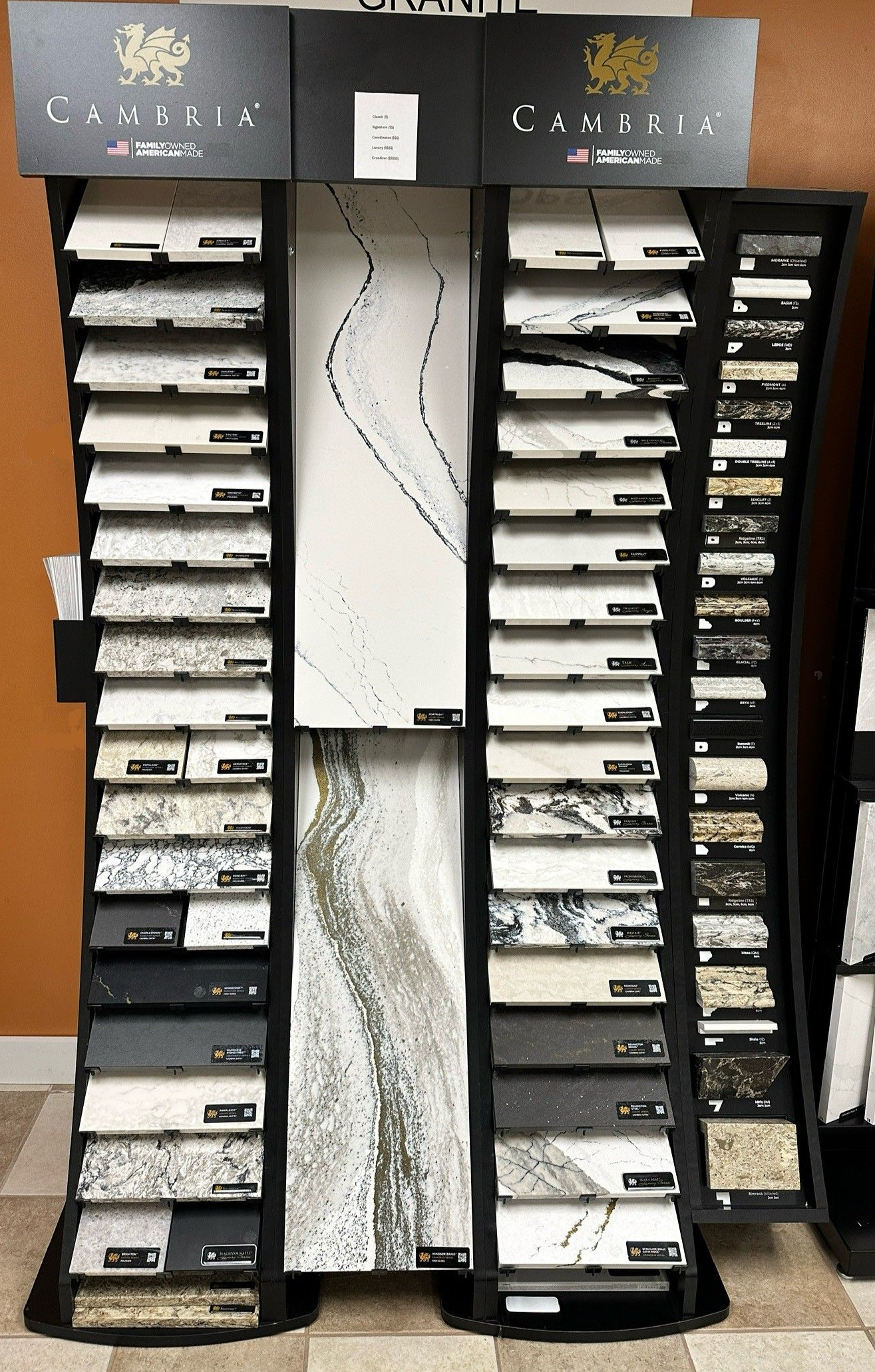 Display stand showcasing various countertop samples; black, white, and patterned granite and marble options.