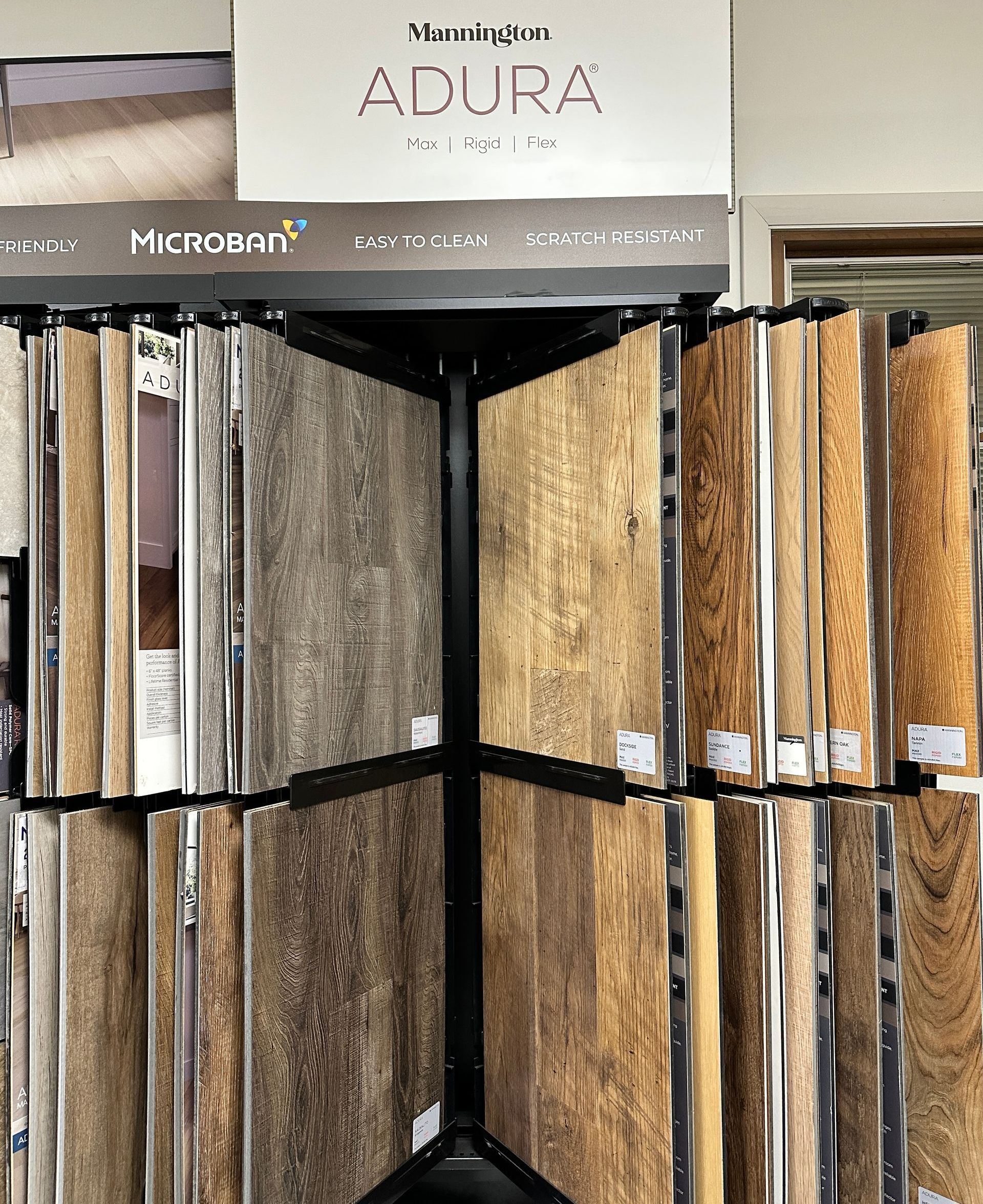 Flooring samples on a rotating display, featuring various wood-look vinyl planks.