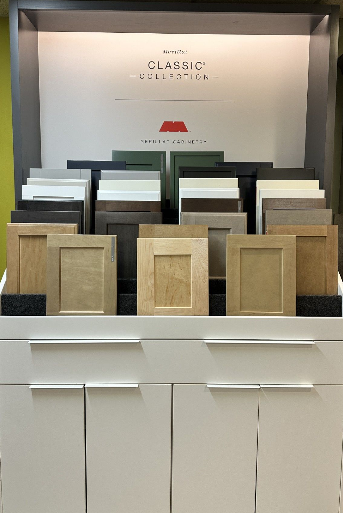 Cabinet display with wood and painted finish samples, featuring a variety of colors and textures.