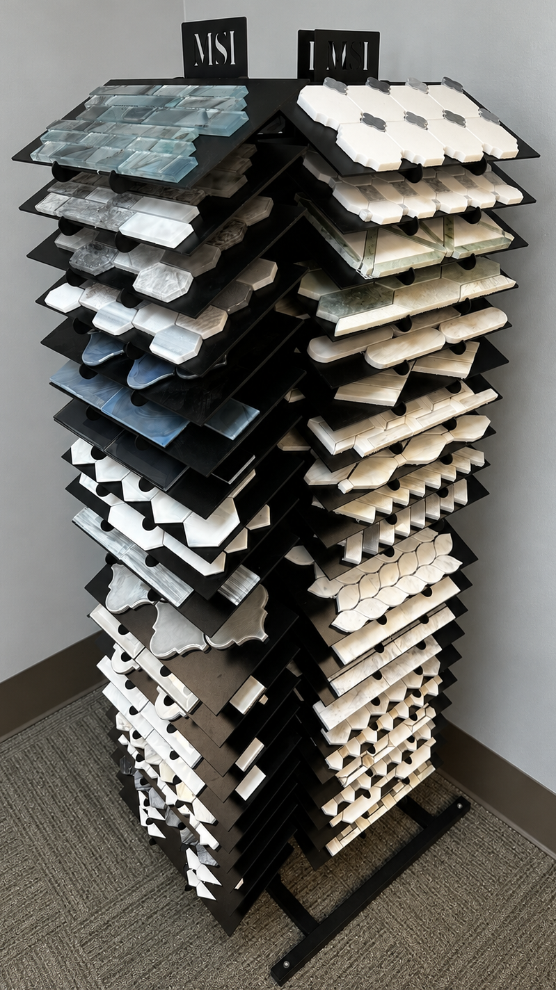 Tile and countertop samples on display in a showroom, arranged on stands.