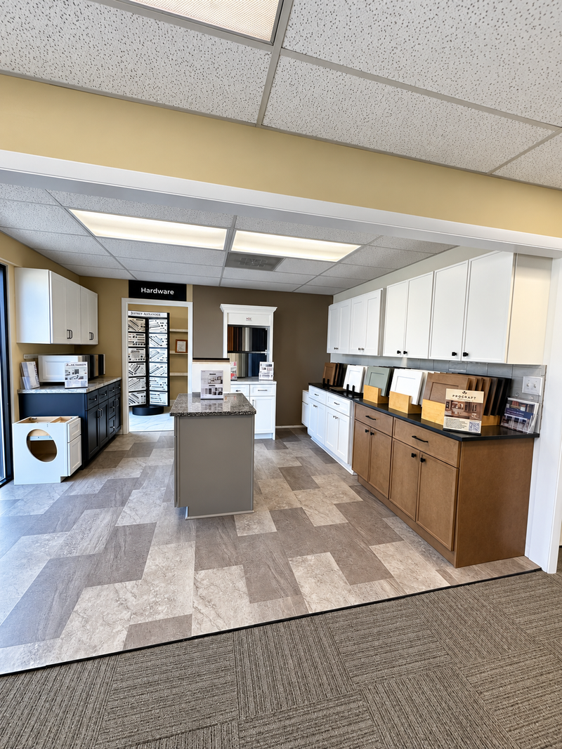 Kitchen and flooring showroom with displays of cabinets, countertops, and flooring samples.
