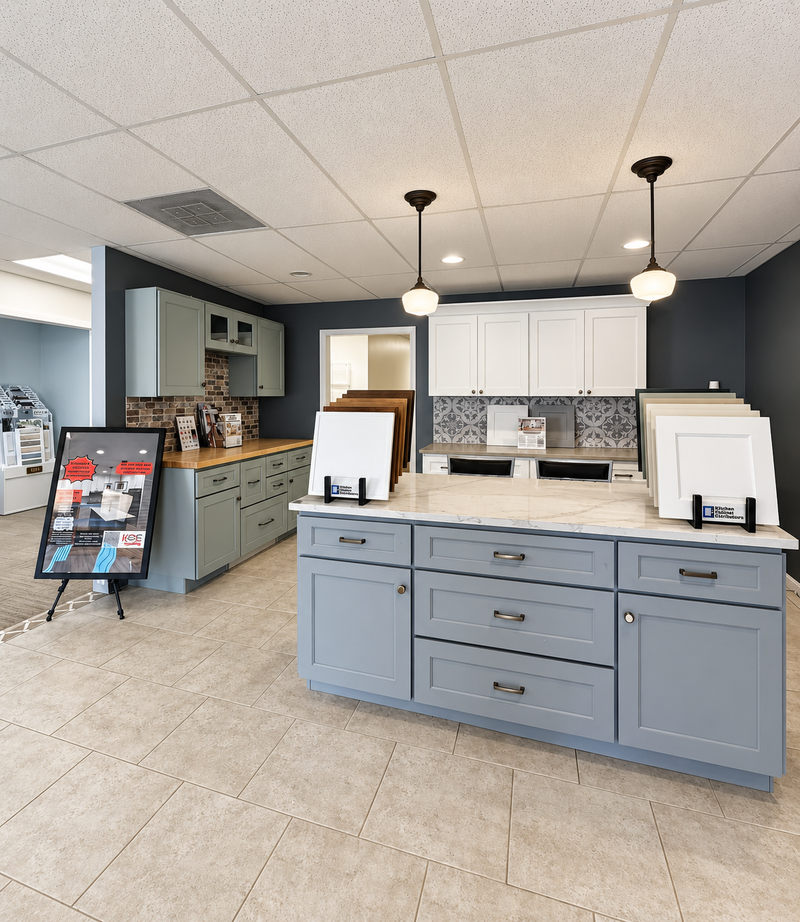 Kitchen showroom with displays of cabinets, countertops, and a small kitchen model with appliances.