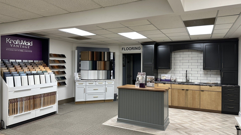 Kitchen and flooring showroom with displays of cabinets, countertops, and flooring samples.