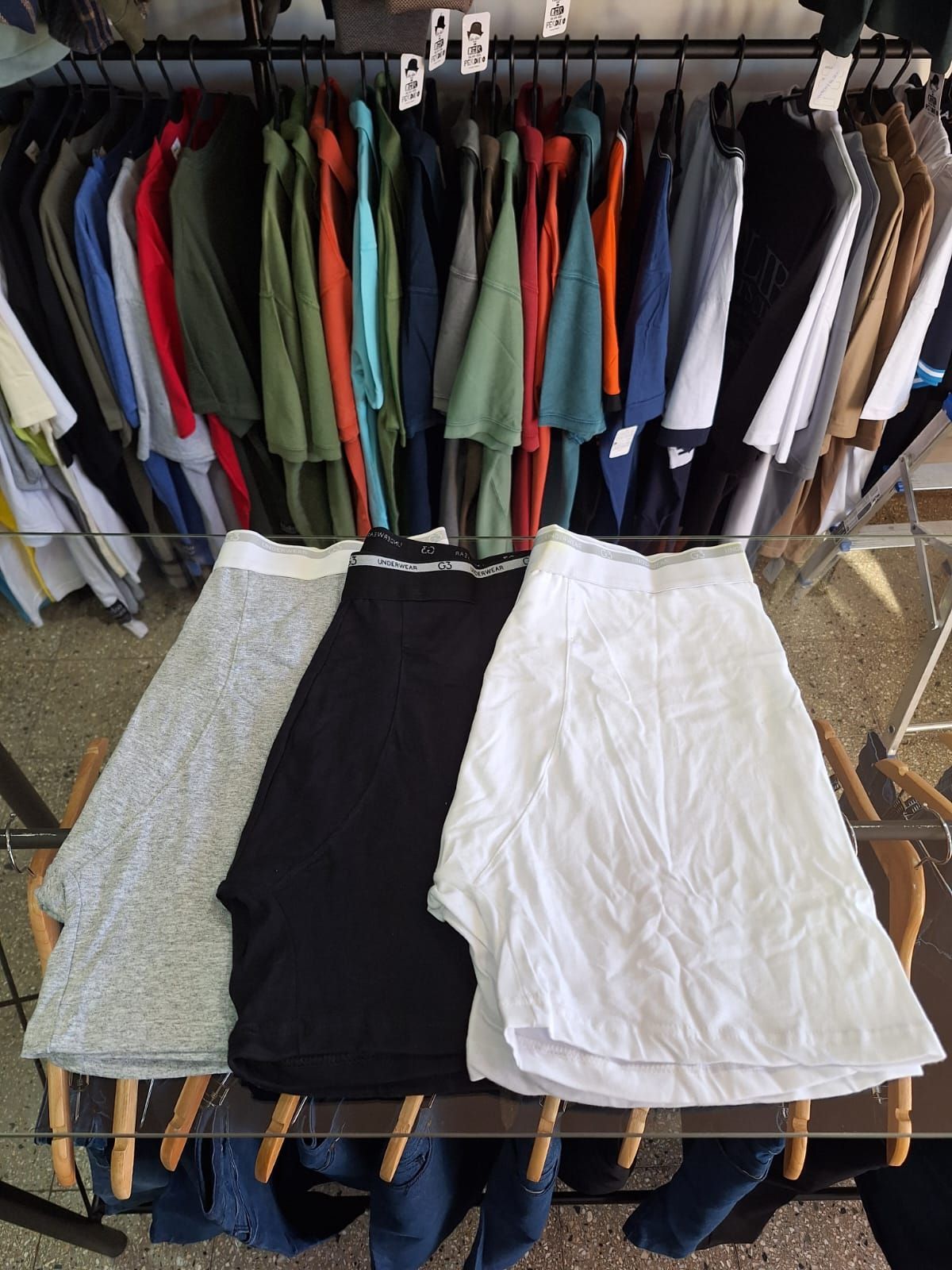 Ropa en perchas sobre faldas expuestas. Varios colores.