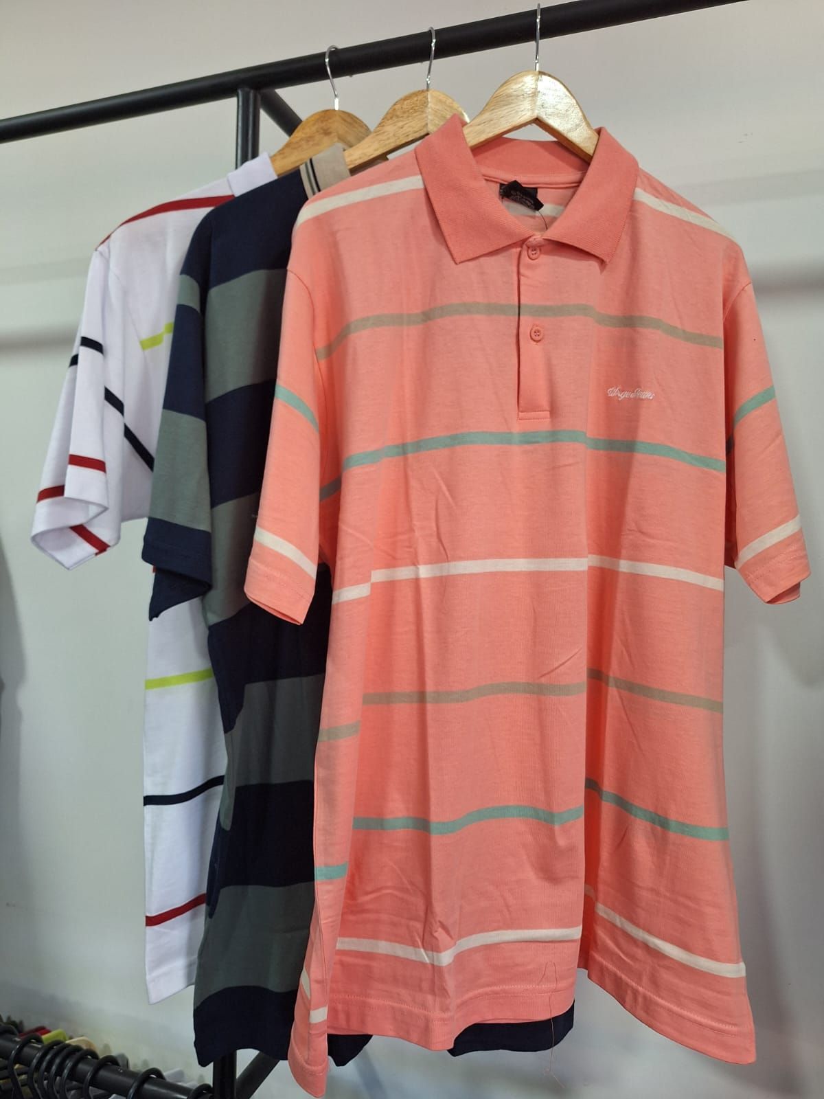 Tres polos con rayas horizontales colgados en un perchero.
