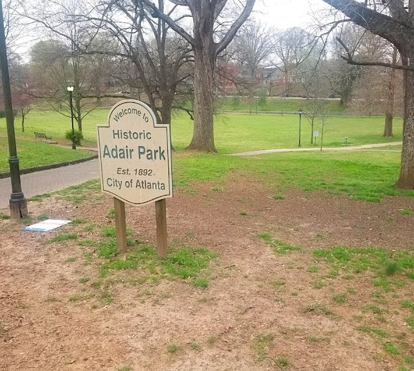 Historic Adair Park sign in a grassy city park with bare trees and a walkway in Atlanta.