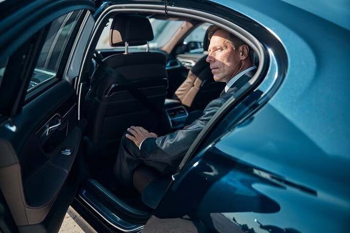 Businessman on a call in the back seat of a car
