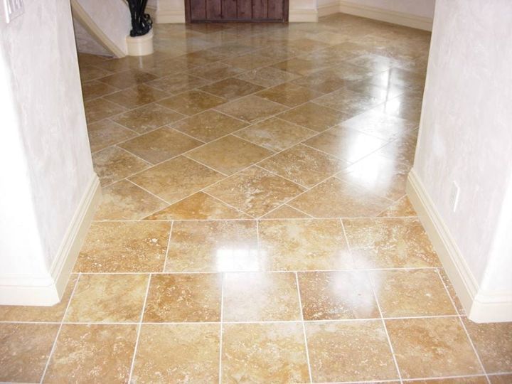 Polished tan tile hallway with white walls and bright floor reflections