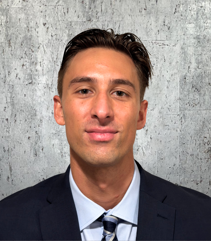 A man in a suit and tie is smiling for the camera.