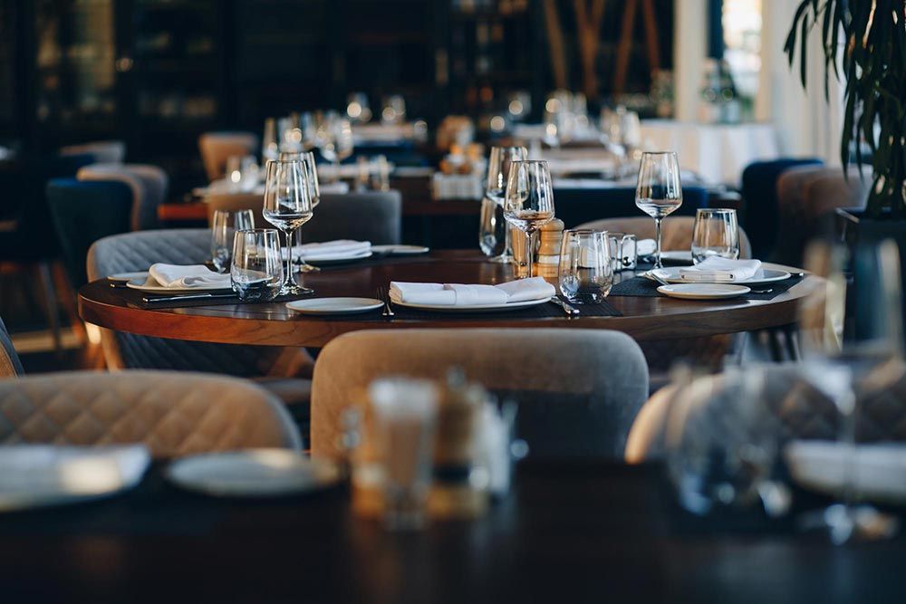 A restaurant with tables and chairs set for a dinner party.
