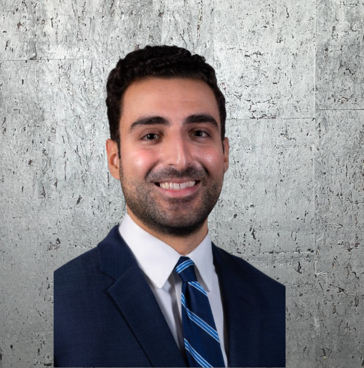 A man in a suit and tie is smiling for the camera