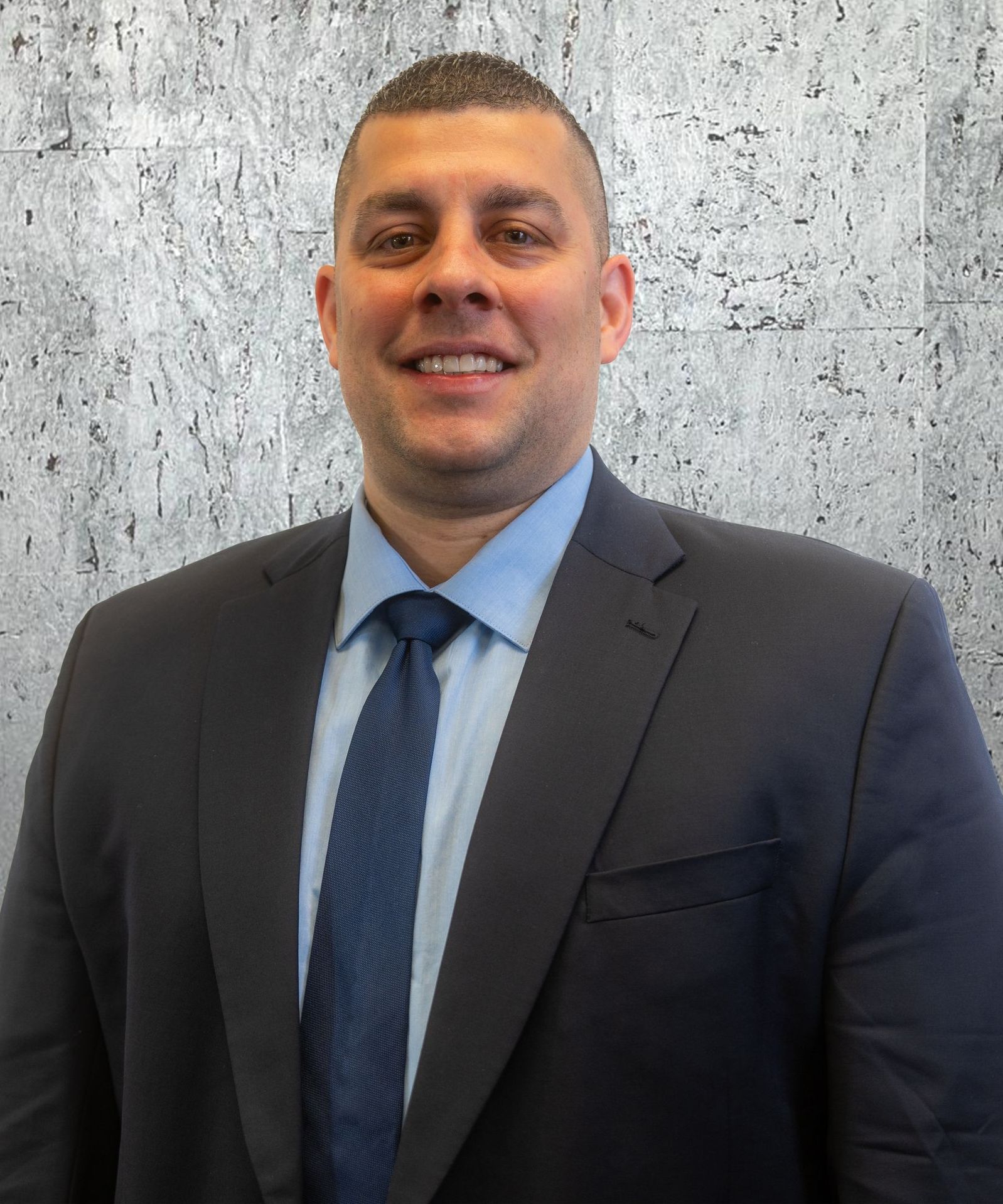 A man in a suit and tie is smiling for the camera.