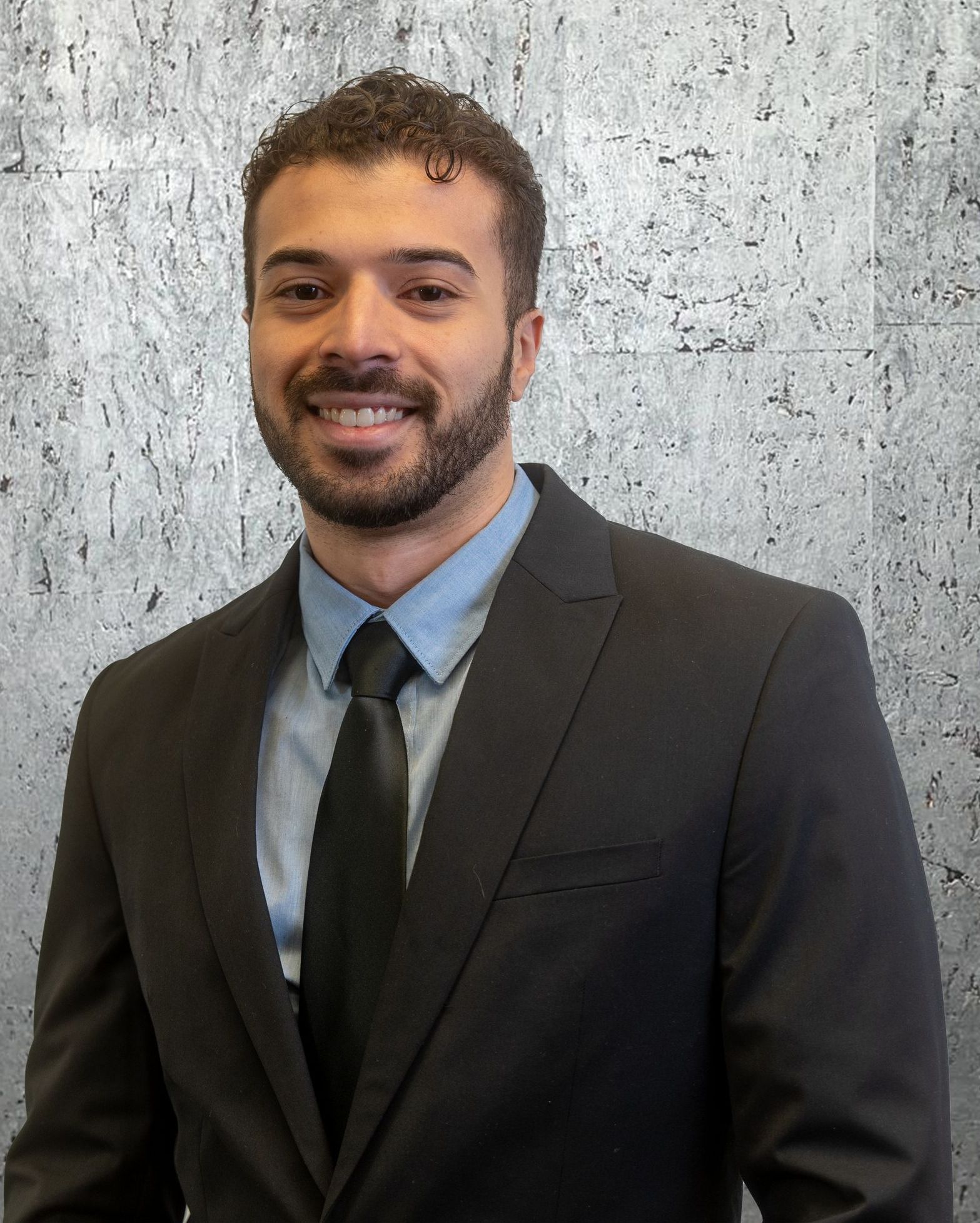 A man in a suit and tie is smiling for the camera.