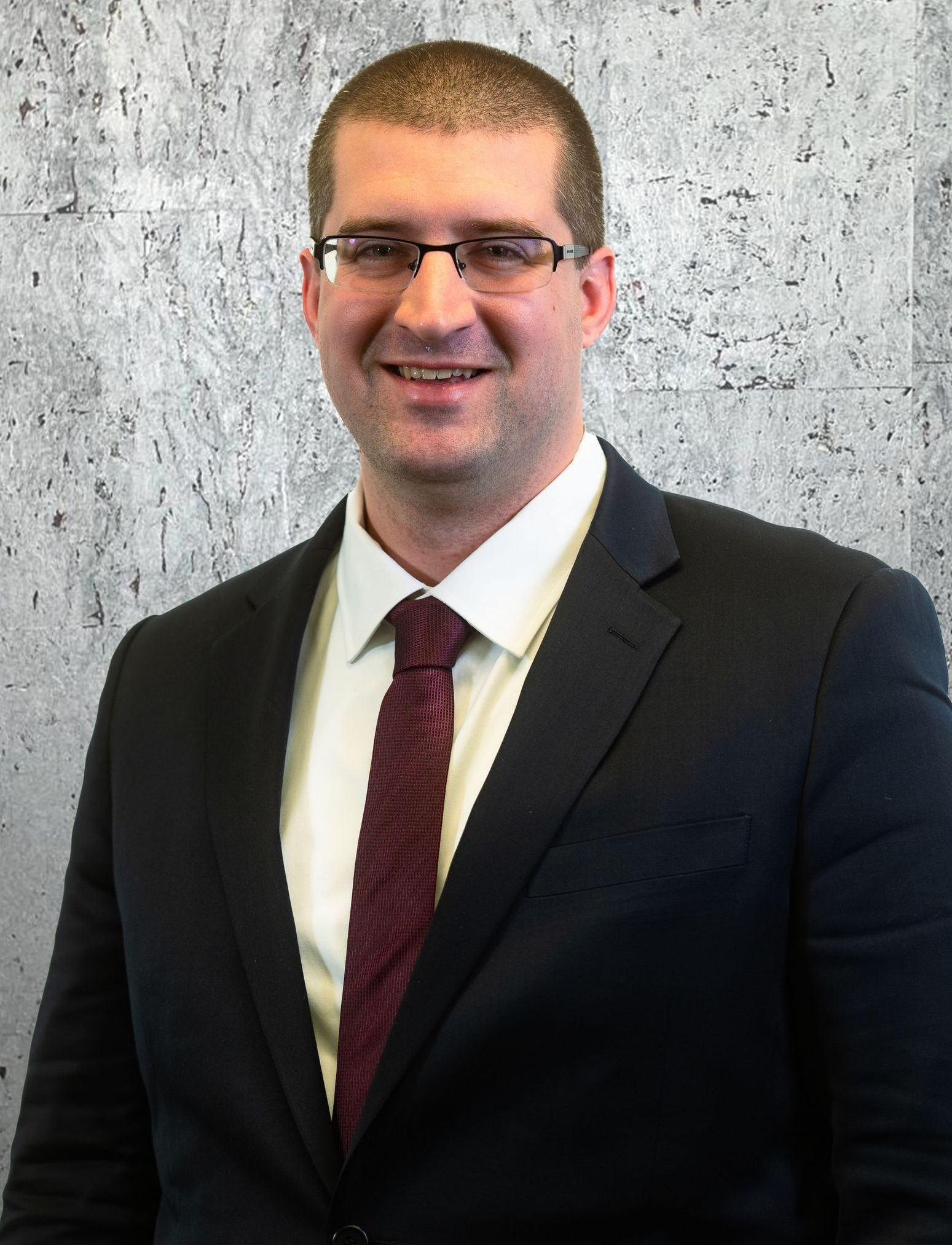 A man in a suit and tie is smiling for the camera.