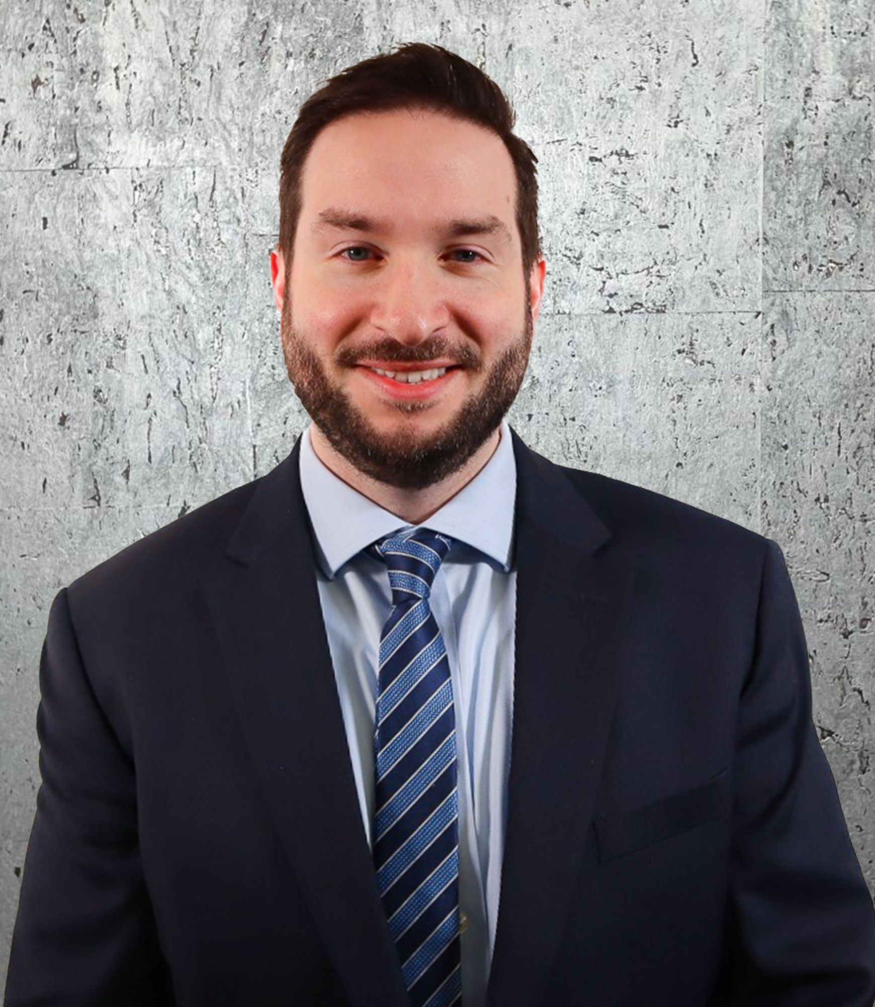 A man in a suit and tie is smiling for the camera.