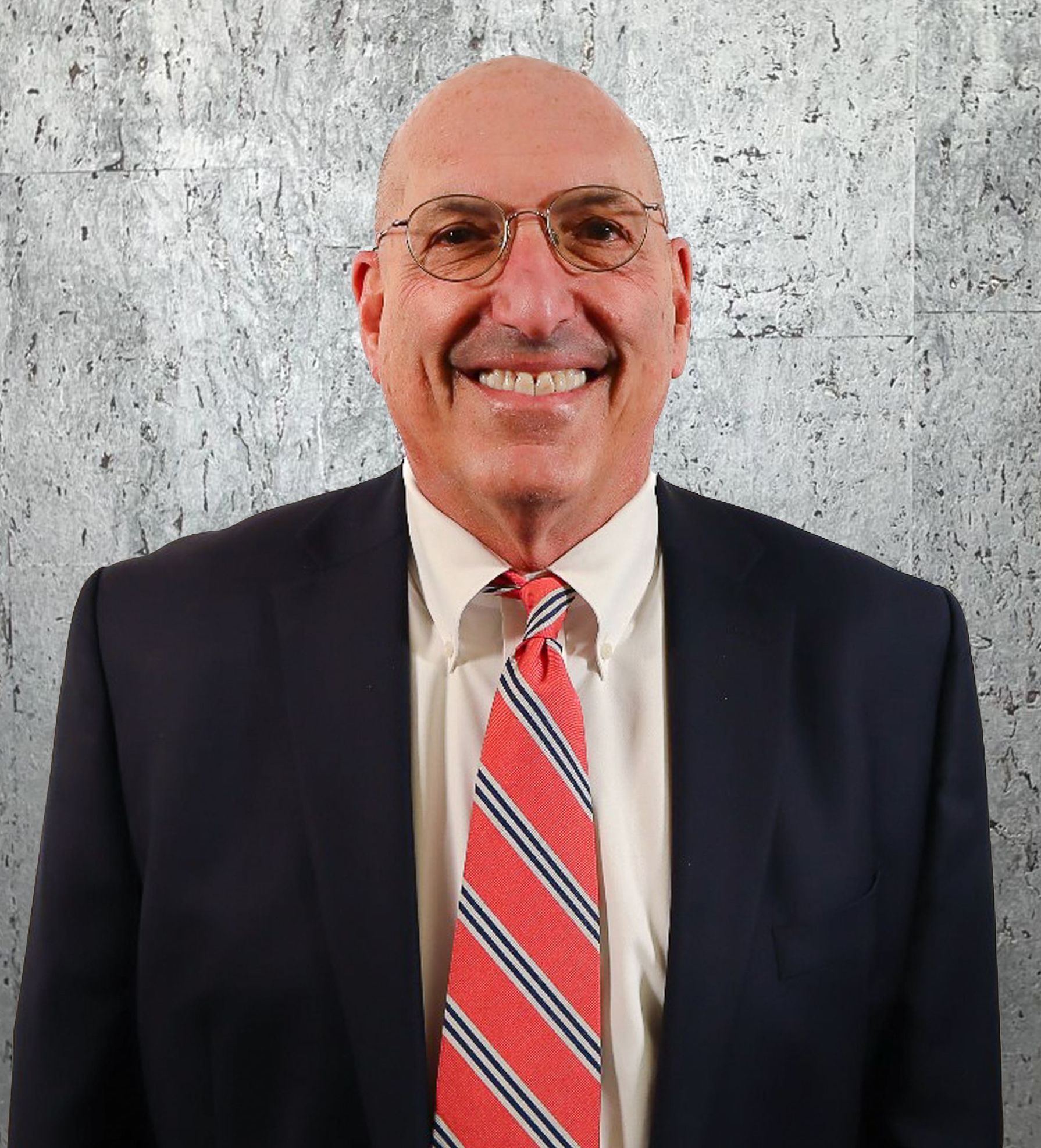 A man in a suit and tie is smiling for the camera.