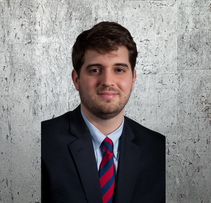 A man in a suit and tie poses for a picture