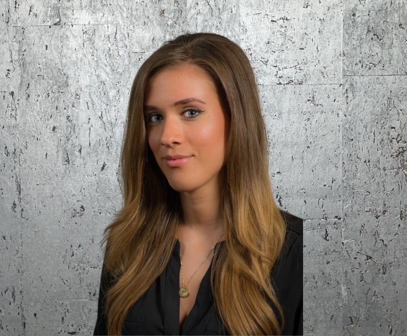 A woman with long brown hair is wearing a black shirt