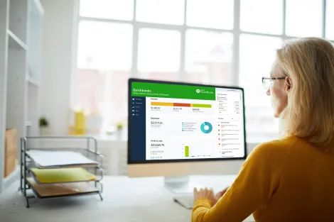 A woman is sitting at a desk using a computer.