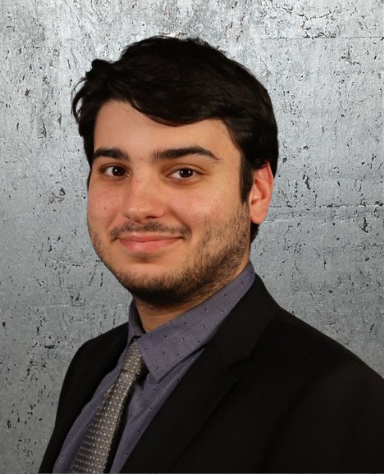 A man in a suit and tie is smiling for the camera