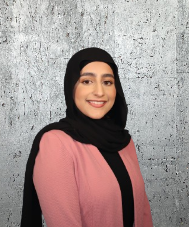 A woman wearing a black scarf and a pink jacket