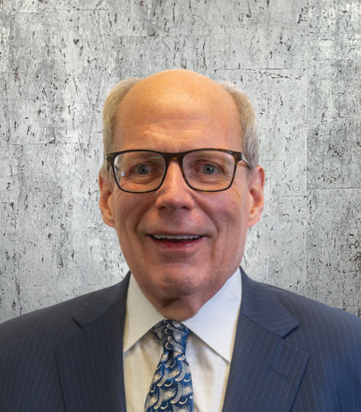 A man in a suit and tie is smiling for the camera