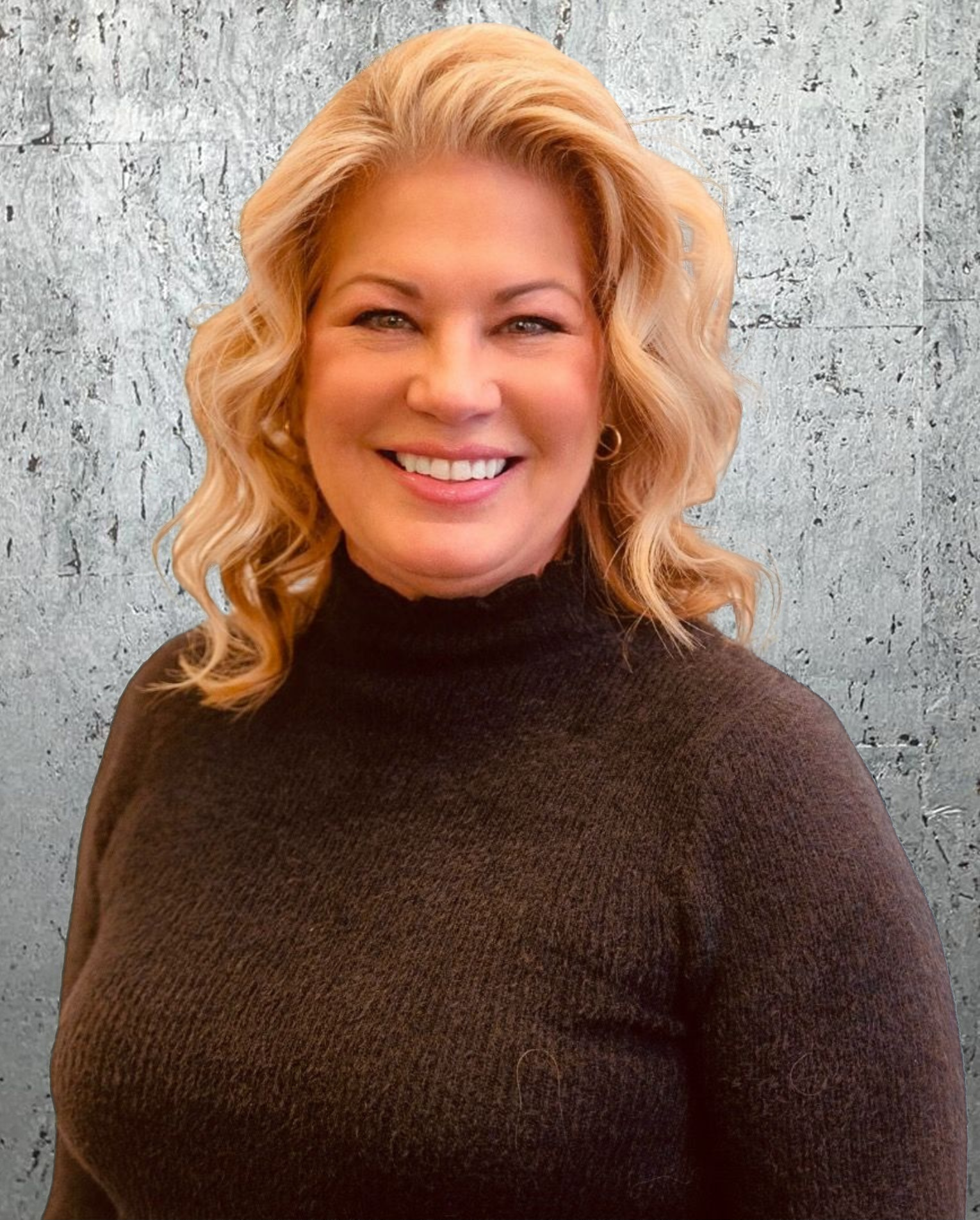 A woman in a black sweater is smiling for the camera.